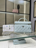 Light blue quilted handbag with gold chain strap and top handle, front flap