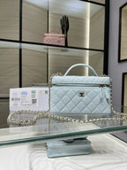 Light blue quilted handbag with gold chain strap and top handle, front flap