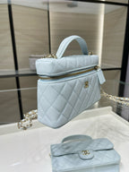 Light blue quilted handbag with gold zipper, top handle, and chain strap