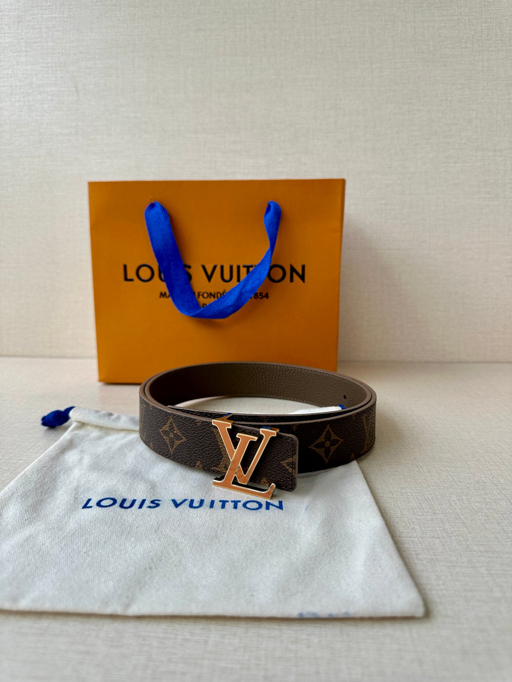 Louis Vuitton monogram belt, dark brown leather with gold-tone LV buckle.
