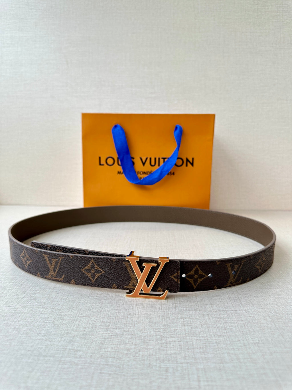 Louis Vuitton monogram belt with gold-tone LV buckle, dark brown leather.