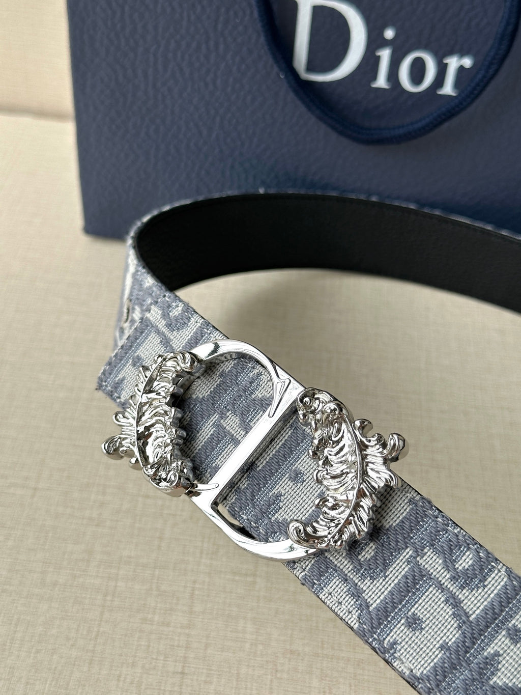 Logo jacquard belt with close-up ornate silver buckle and gold-accented detailing