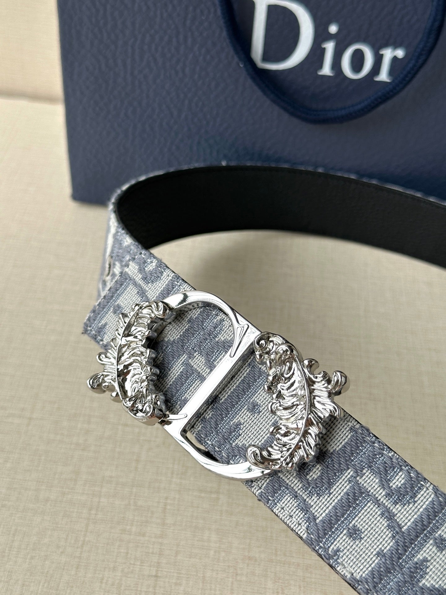 Logo jacquard belt with close-up ornate silver buckle and gold-accented detailing