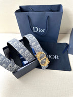 Logo jacquard belt with gold buckle alongside dark leather belt strap