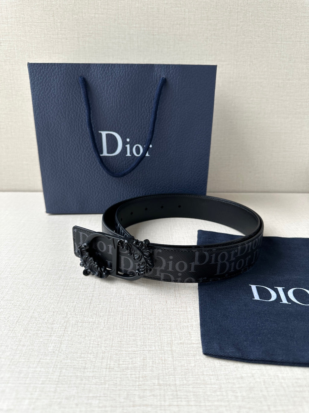 Dior belt on display with dark monogram strap and black decorative buckle