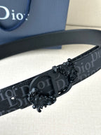 Dior belt close-up: dark monogram strap with black ornate buckle and embossed Dior logo