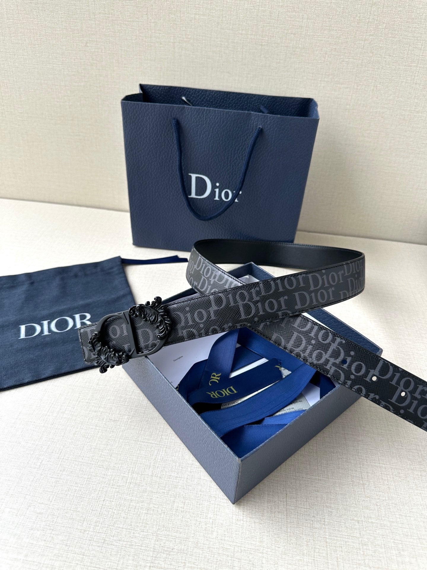 Dior belt with dark monogram strap and black floral-style buckle