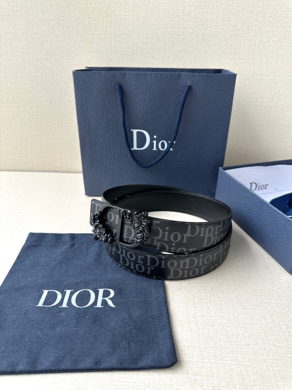 Dior belt with dark monogram strap, black buckle, and contrast pinhole trim