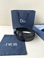 Dior belt with dark monogram strap, black buckle, and contrast pinhole trim