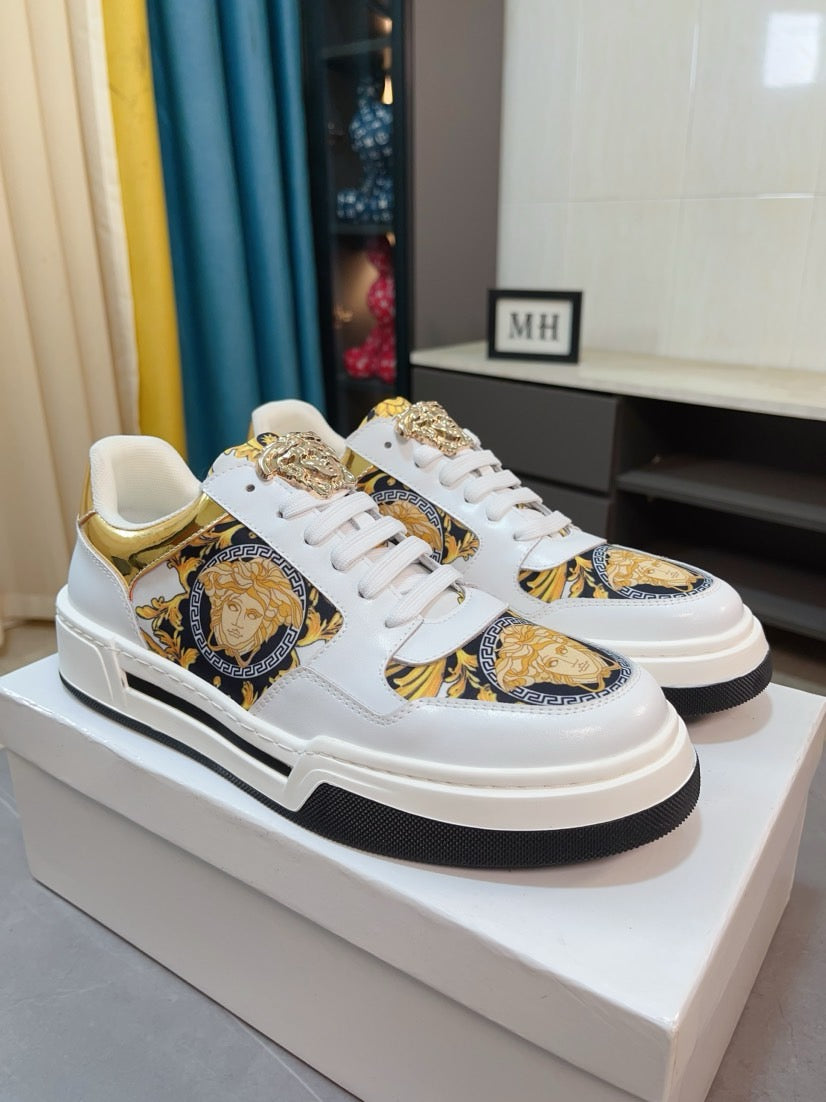 Pair of white lace-up sneakers with gold baroque medallion panels and chunky rubber sole.