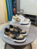 Black and gold lace-up sneakers with white rubber sole and decorative medallion panels.