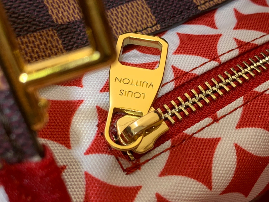 Louis Vuitton gold zipper pull clasp on red patterned fabric