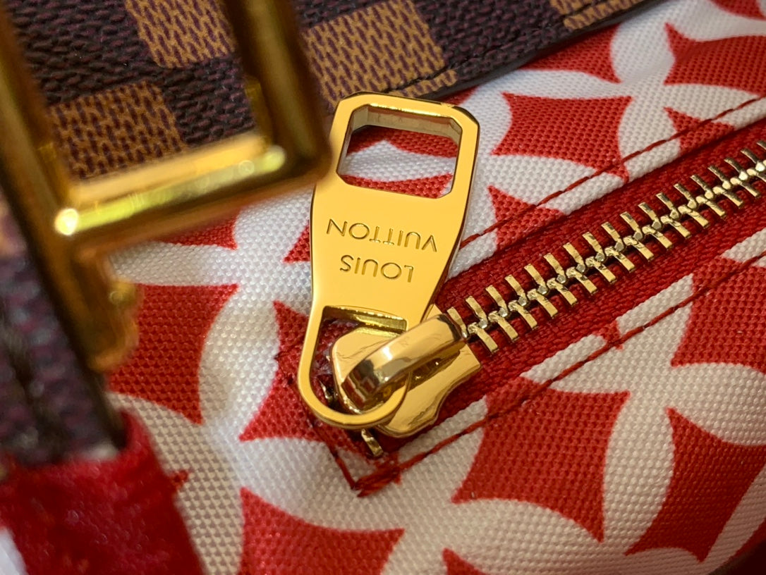 Louis Vuitton gold zipper pull clasp on red patterned fabric