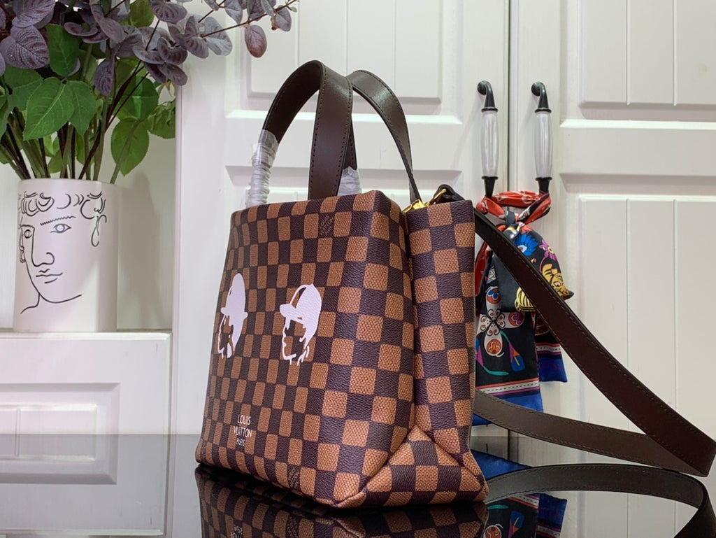 Louis Vuitton Damier checkered tote bag with white character patch and brown shoulder strap
