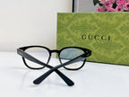 Black Gucci eyeglasses with blue-tinted lenses and clear frame edges