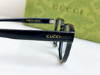 Black Gucci eyeglasses close-up of temple with Gucci logo and metal hinge