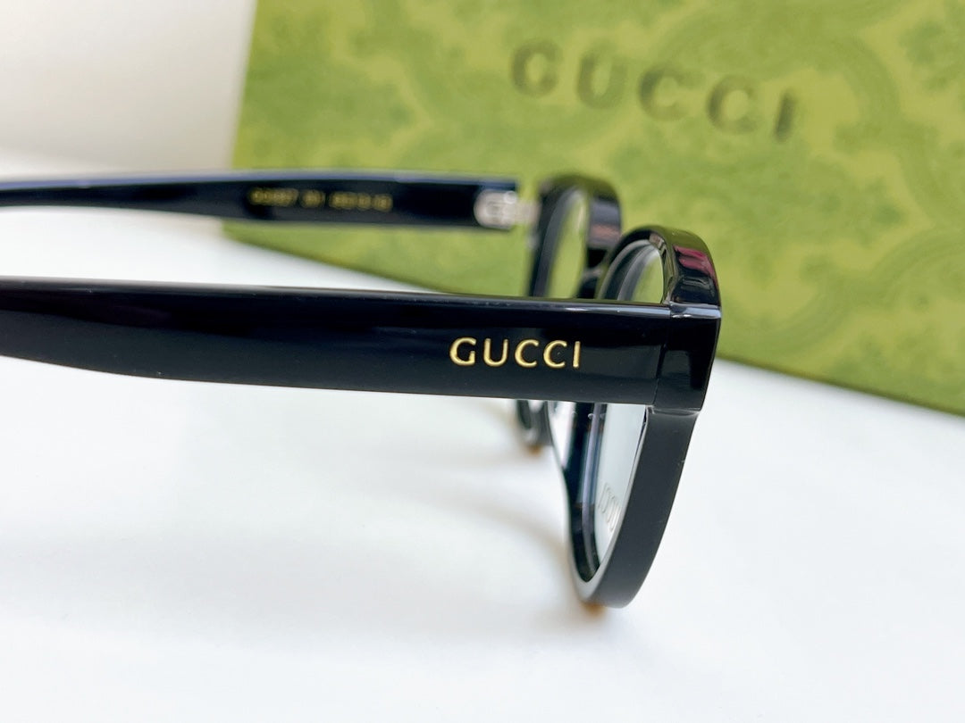 Black Gucci eyeglasses close-up of temple with Gucci logo and metal hinge