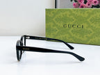 Black Gucci eyeglasses with curved temple tips and clear lenses