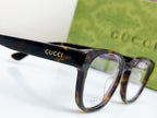 Gucci eyeglasses close-up of temple logo and front frame with blue-tinted lens