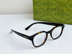 Gucci eyeglasses laid out with black and tortoiseshell frames and curved temples