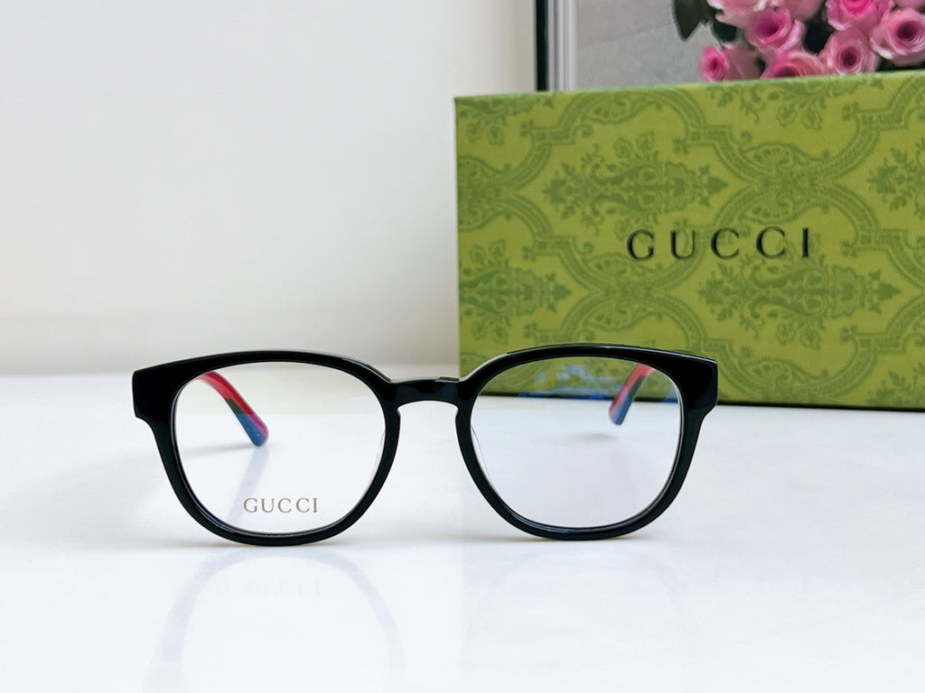 Black Gucci eyeglasses with white lenses and red-green temple accents