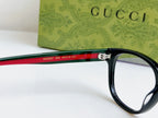 Black Gucci eyeglasses, red-green temple band with Gucci details