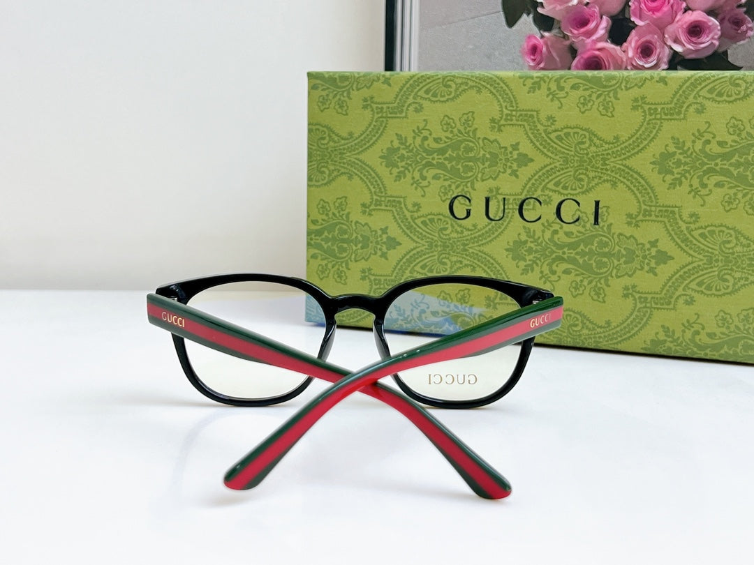 Black Gucci eyeglasses with red-green temples, crossed angle view