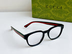 Black Gucci eyeglasses with red temple arms and curved frame