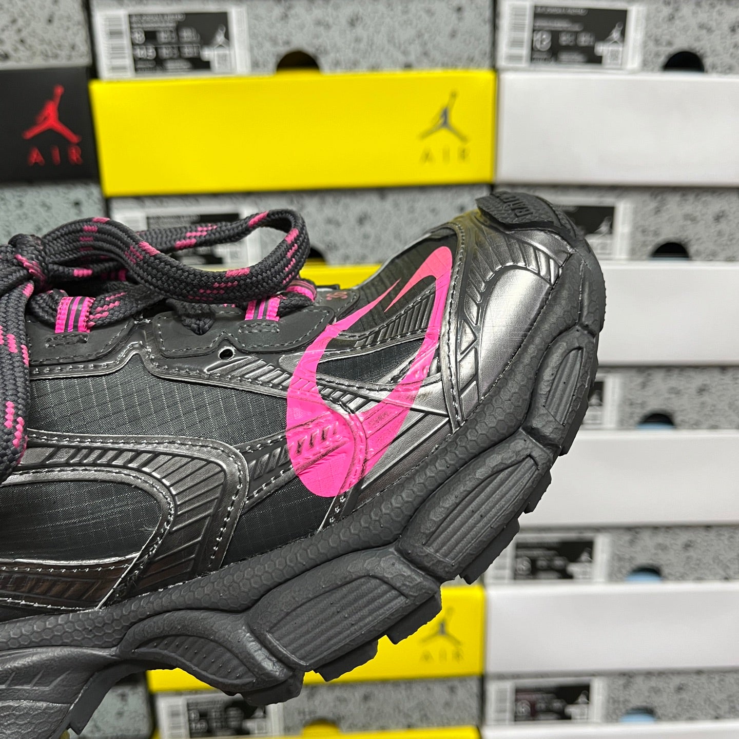 Balenciaga dark gray sneaker side view with pink swoosh and textured midsole