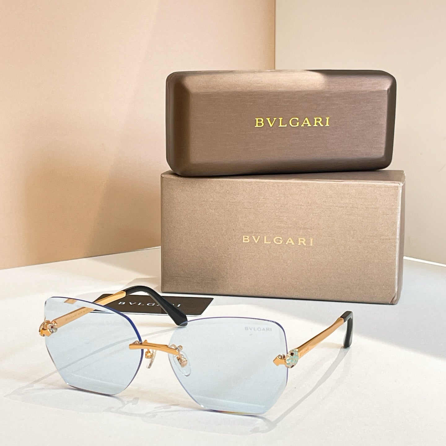 Bvlgari eyeglasses, pale blue lenses, gold-tone frame, black temples.