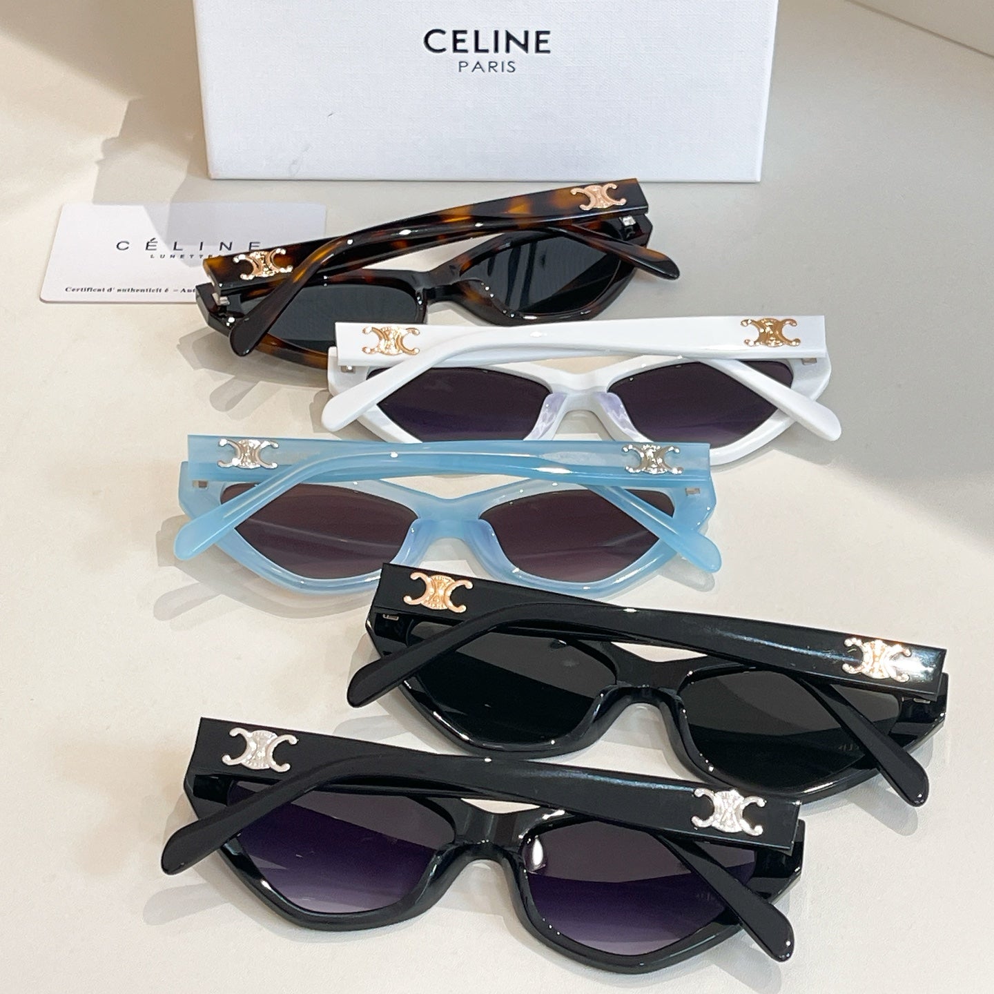 Assorted cat-eye sunglasses in white, blue, tortoiseshell, and black frames