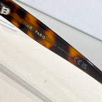 Tortoiseshell sunglasses with printed temple text and dark lenses
