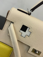Close-up of white textured leather handbag with patch detail and metal clasp