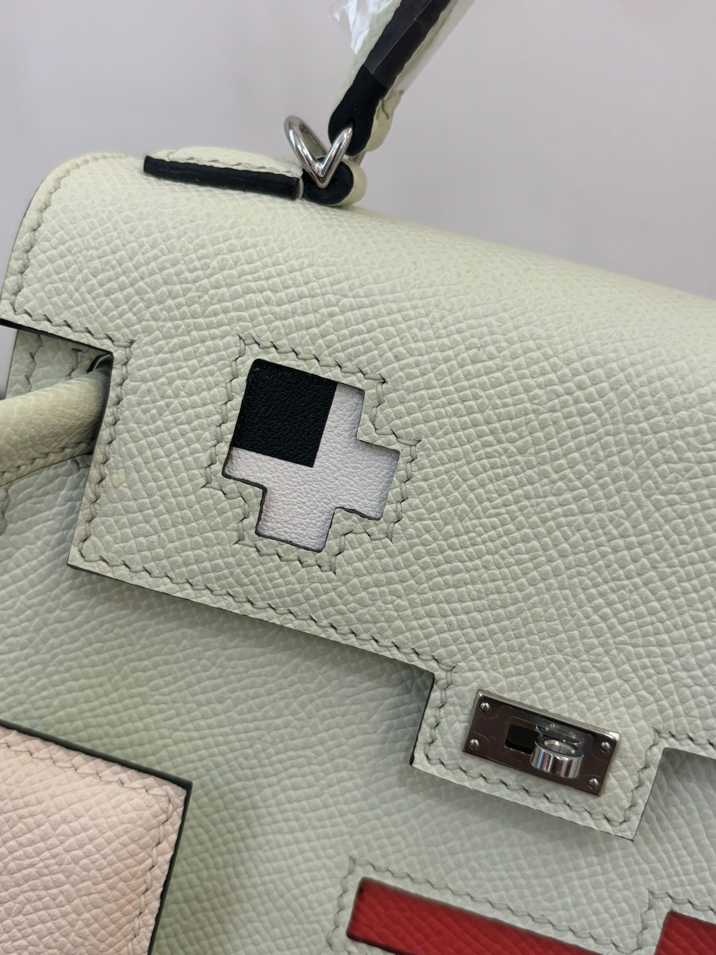 Hermes bag close-up of light mint leather with square patch and metal clasp