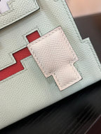Hermes bag leather close-up with light mint panels and red stitched inset detail