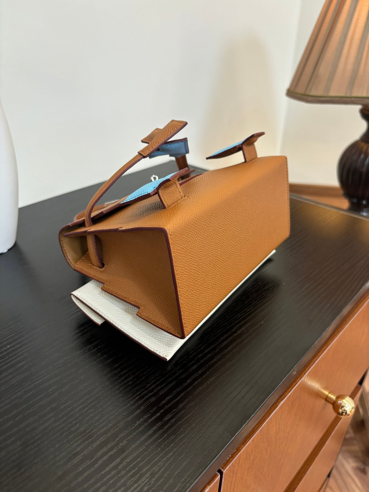 Hermes bag in tan leather with side strap details and top handle, back view
