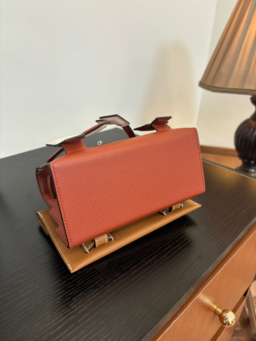 Hermes handbag back view, tan textured leather with folded flap and metal hardware