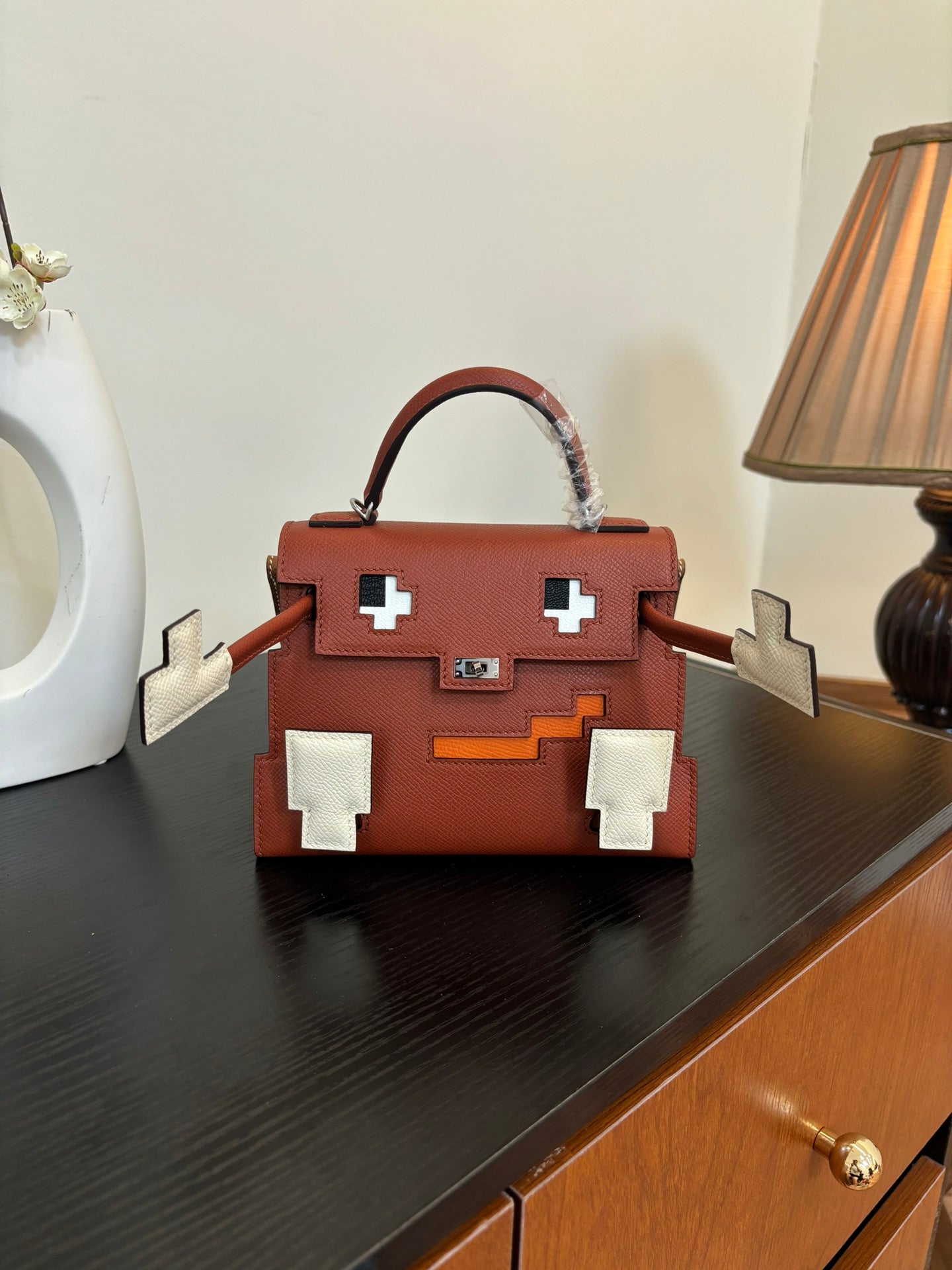 Hermes top-handle handbag front view, red-brown leather with white cross plaques and lock