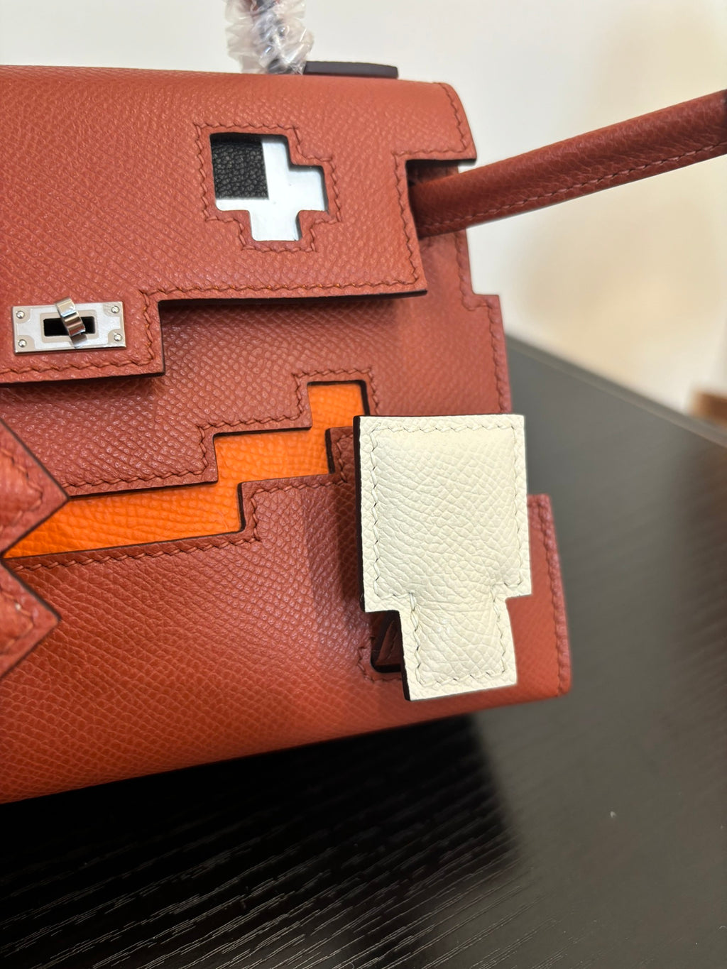 Hermes handbag close-up, red-brown flap with white cross plaques and silver lock