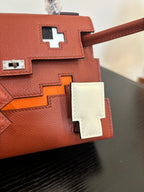 Hermes handbag close-up, red-brown flap with white cross plaques and silver lock