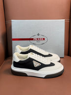 Prada unisex sneakers, white upper with black panel, gold-tone logo patch, lace-up.