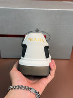 Prada unisex sneaker heel, white back panel with black sides and Prada branding.