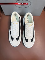 Prada unisex sneakers in white with black side panels, lace-up front, rubber sole.
