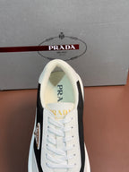 Prada unisex sneaker tongue and lace area, white with Prada logo embroidery.