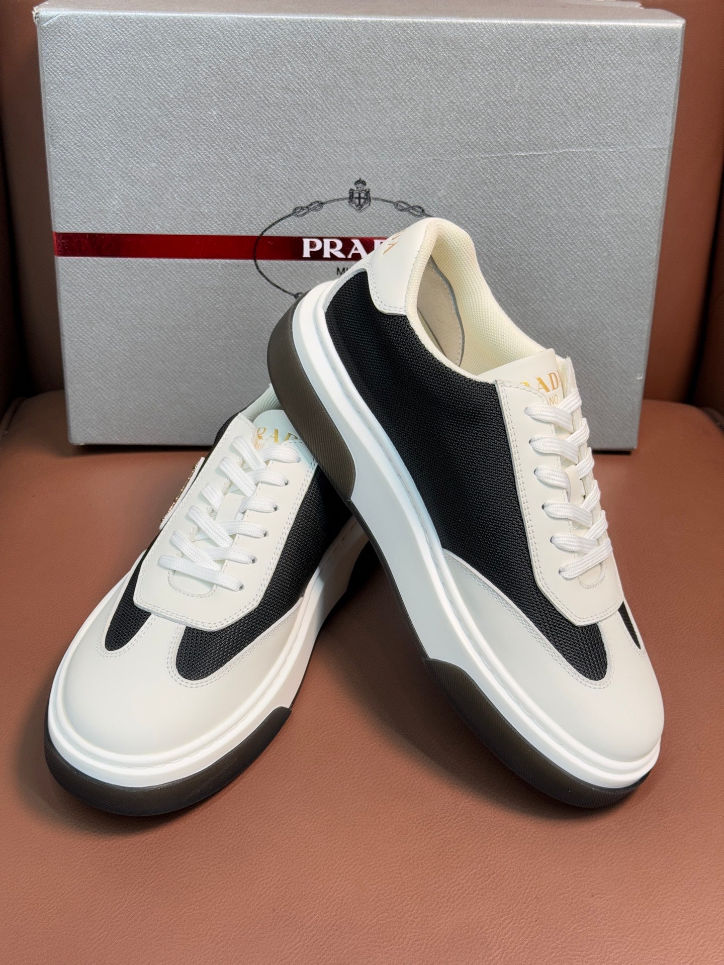 Prada unisex sneakers, white laces and black side panel, cushioned tongue with logo.