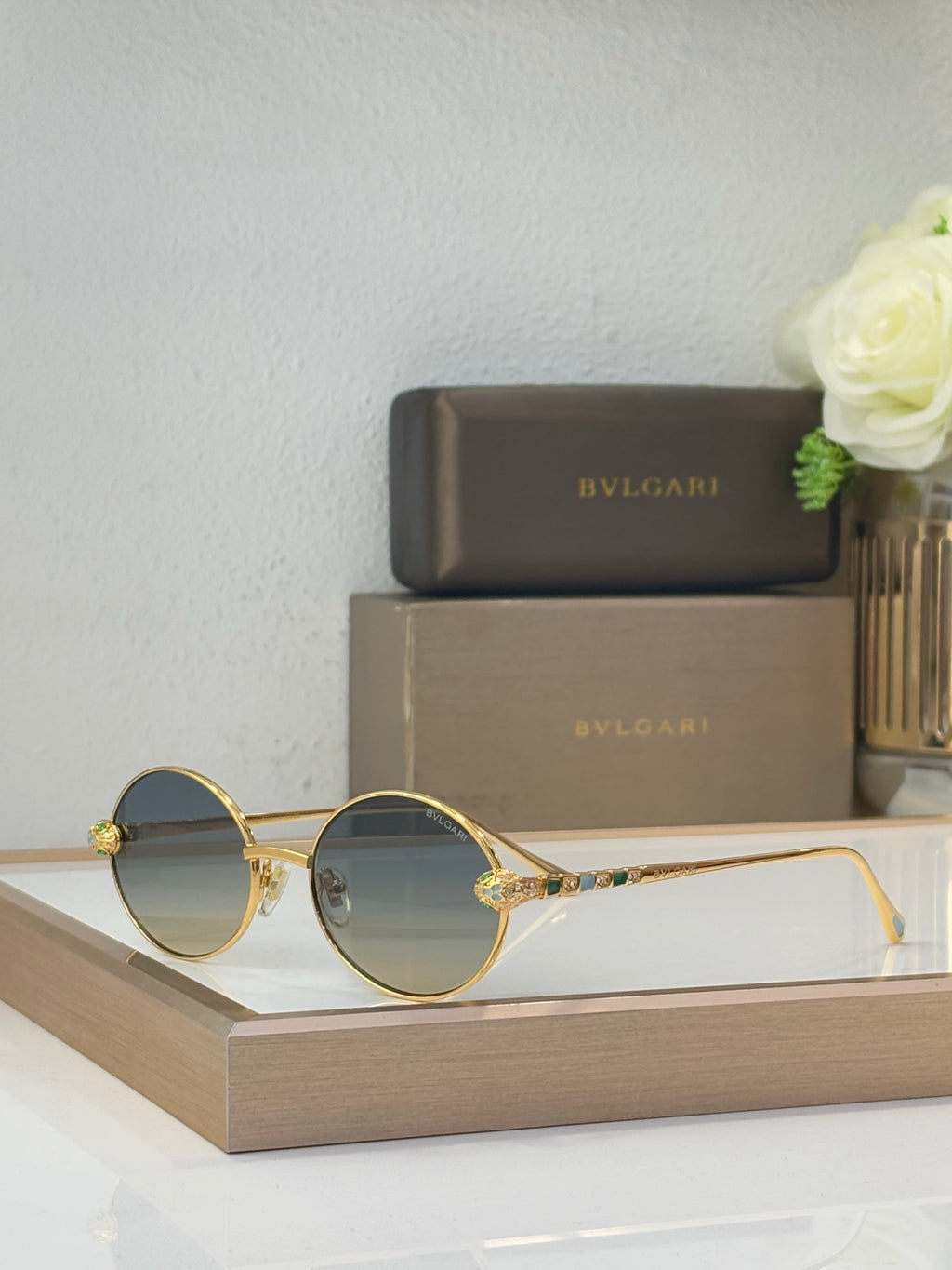 Bvlgari round sunglasses with gradient blue lenses and gold-tone metal frame, jewel accents