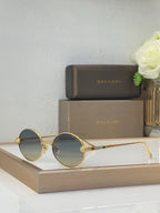 Bvlgari round sunglasses with gradient blue lenses and gold-tone metal frame, jewel accents