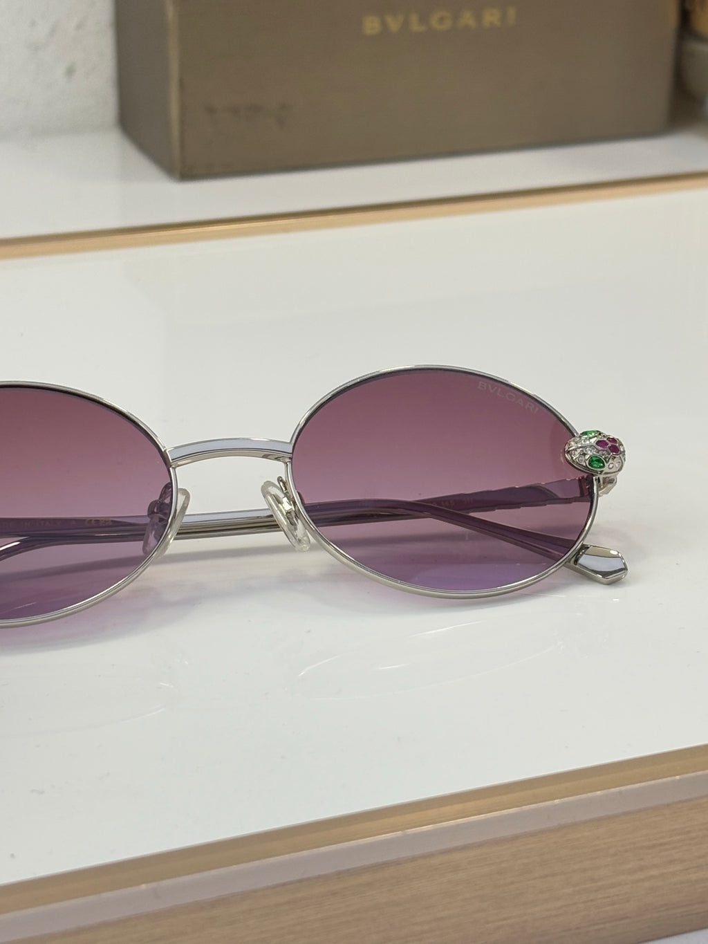 Bvlgari round sunglasses close-up with purple lenses and silver-tone metal frame