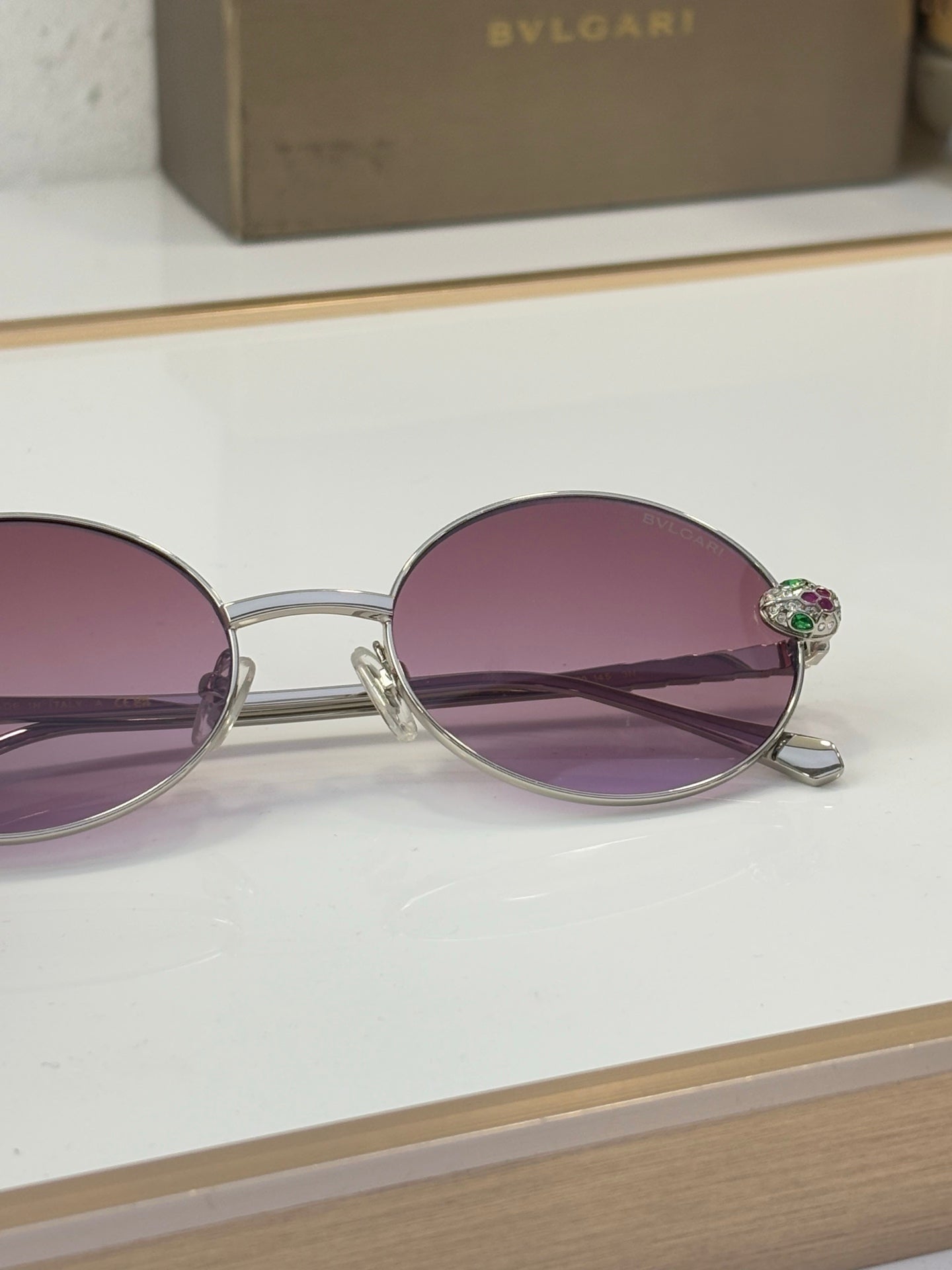 Bvlgari round sunglasses close-up with purple lenses and silver-tone metal frame