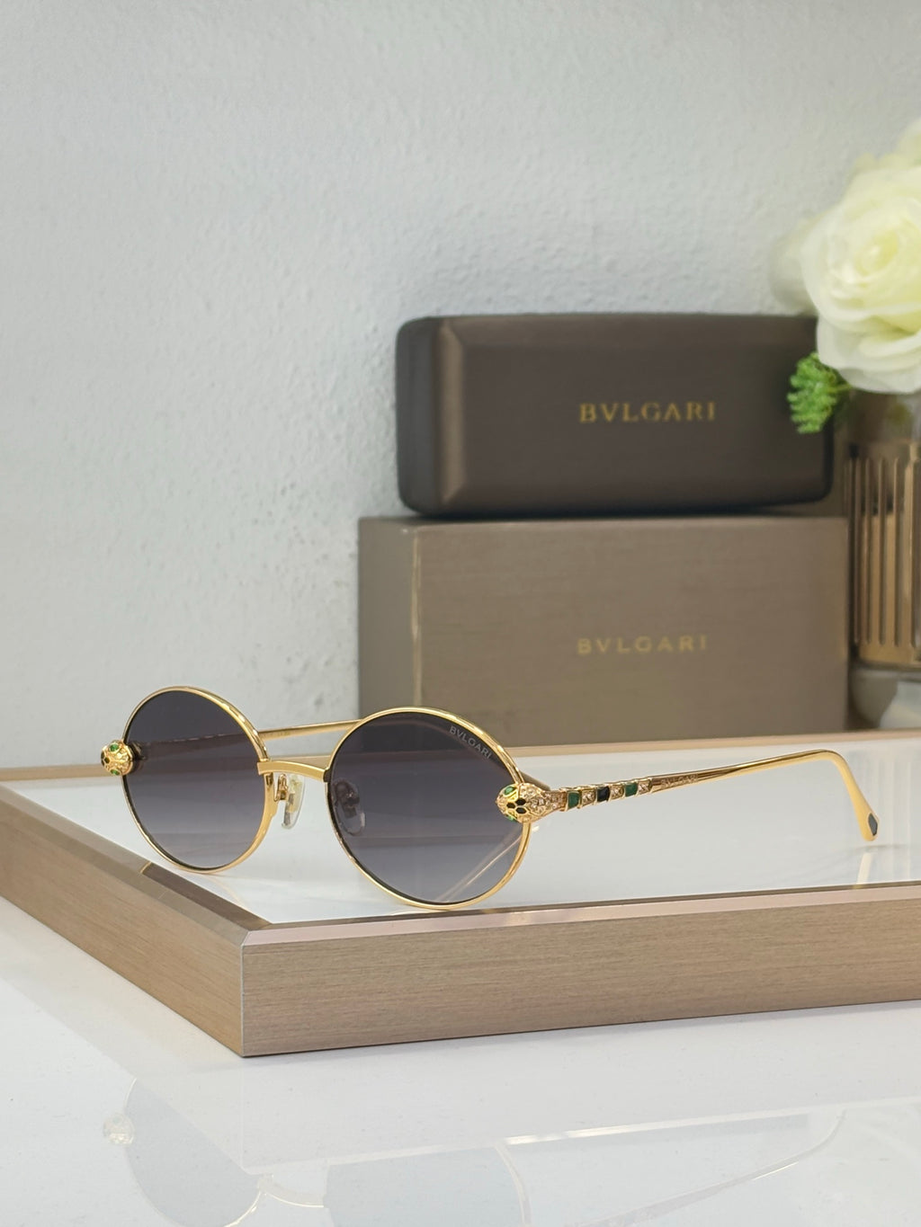 Bvlgari round sunglasses with dark lenses and gold-tone metal frame, colorful jewel details